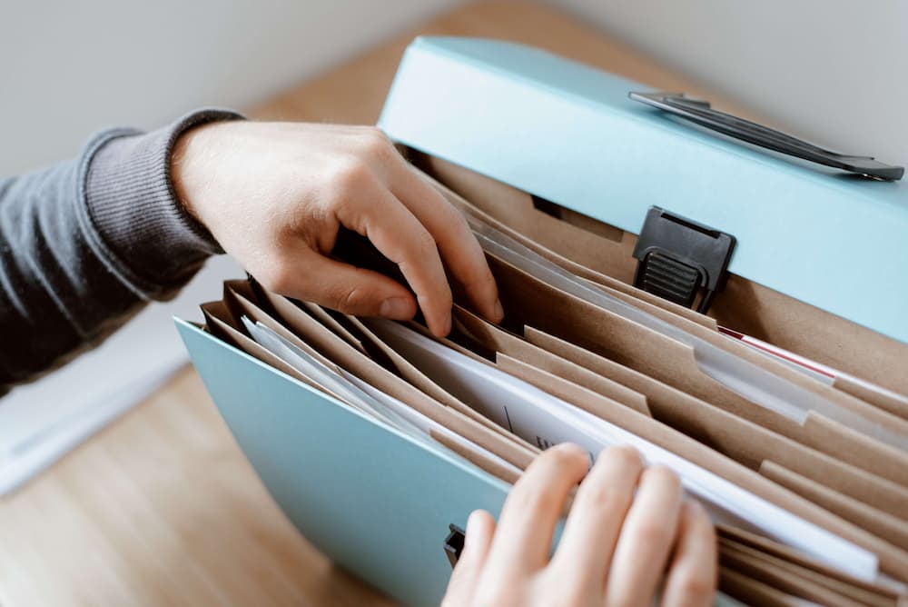 a person holding a folder with files in it