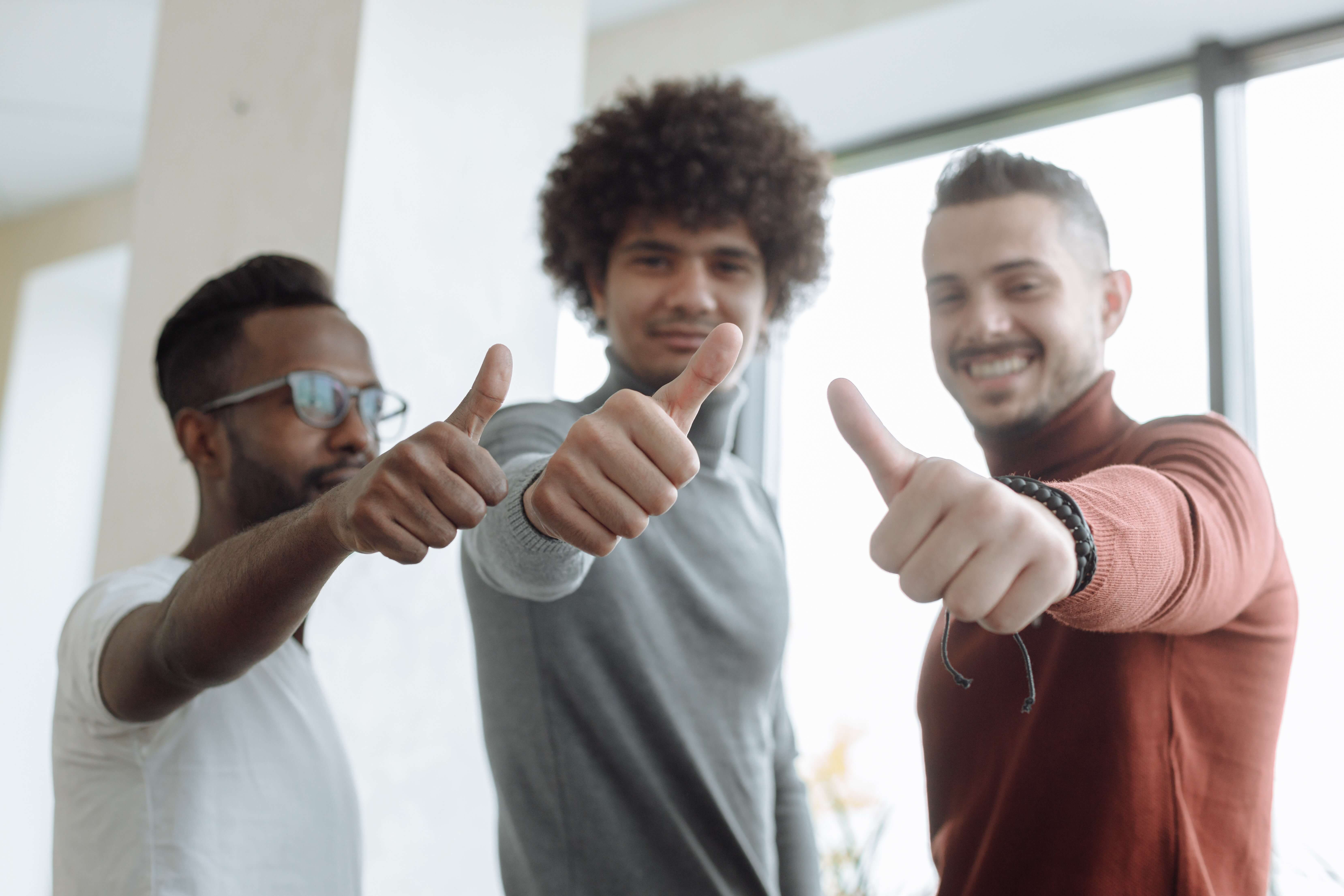 two men are pointing their fingers at the camera