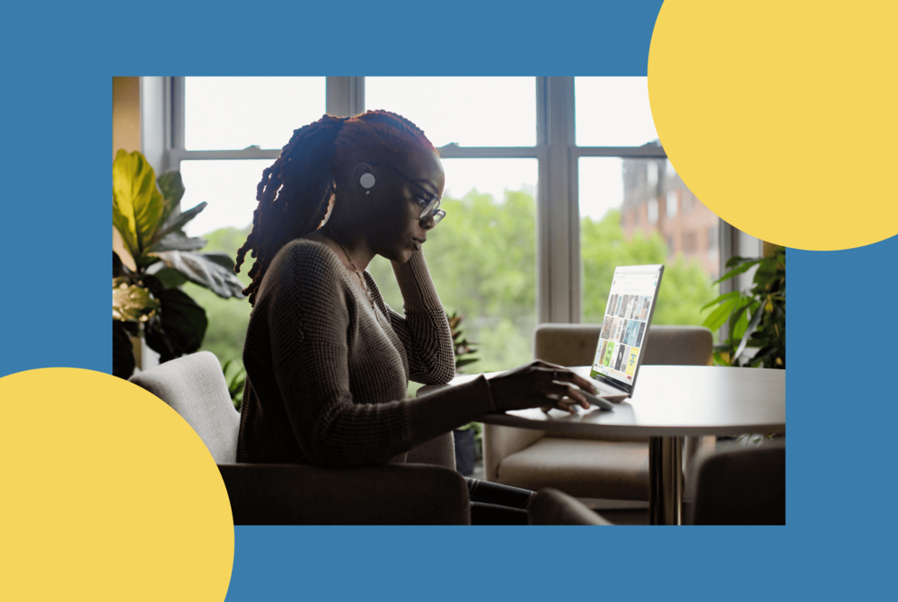 A woman working from home at a table with a laptop.