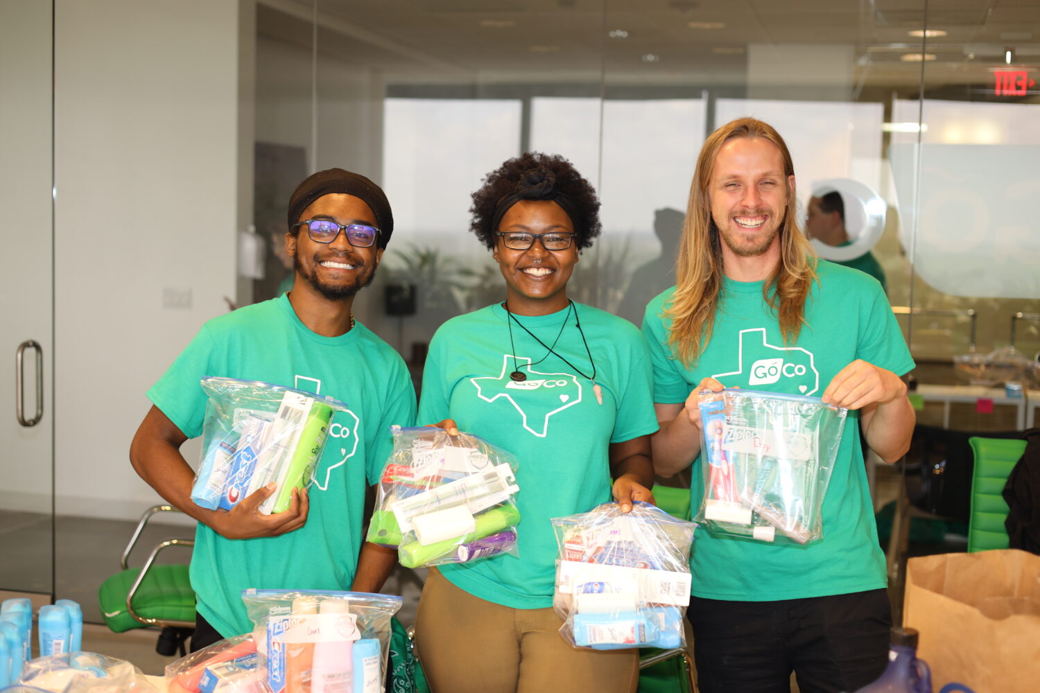 Team holding toiletry kits