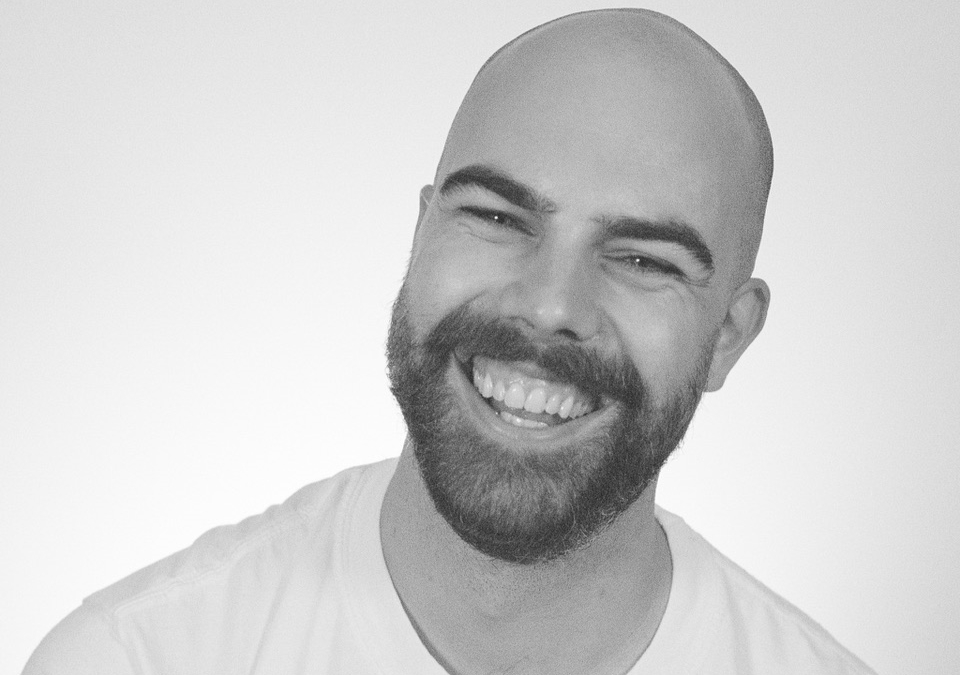 a man with a beard smiles at the camera