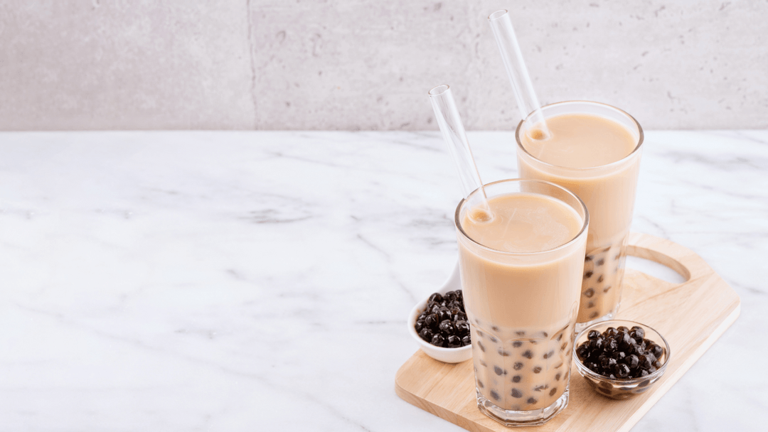 two glasses of bubble tea sitting on a table