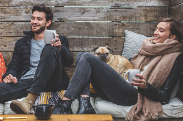 Two millennials relaxing with a dog, perhaps taking a break from work