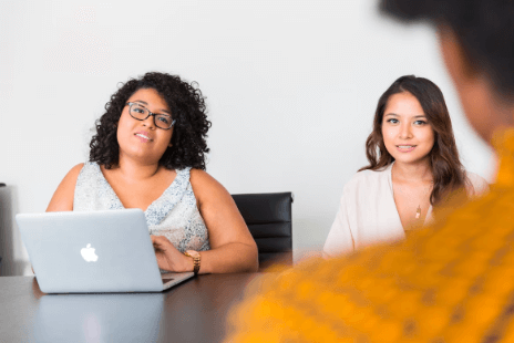 an in person interview. the two recruiters are on a laptop