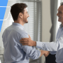 two men shaking hands in an office