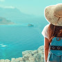 a woman in a hat looking at the ocean