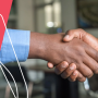 two men shaking hands in an office
