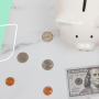 a piggy bank with money laying next to it