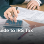 A person works on tax paperwork with the help of a calculator.