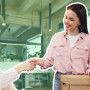 a woman handing a box to another woman