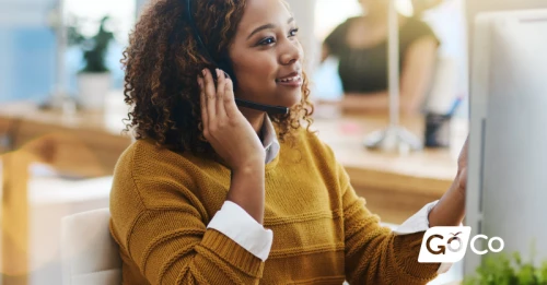 a woman talking on the phone while sitting at her desk