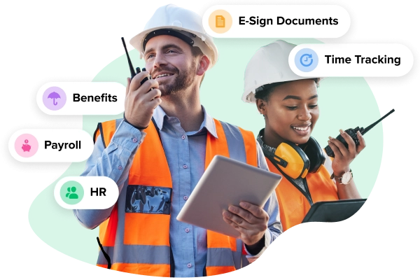 two people in hard hats and safety vests, one holding a tablet and the other holding a
